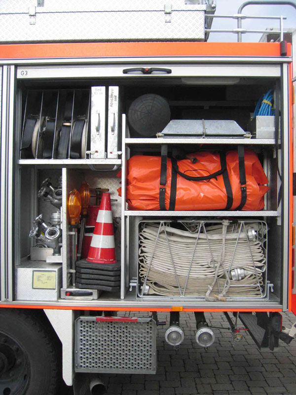 Blick in den Geräteraum G3:

mit C-Schlauchtragekörben, Sprungretter, Kanalblasen, Auffangwannen, weiteren C-Schläuche, Verkehrsabsicherung, Verteilern